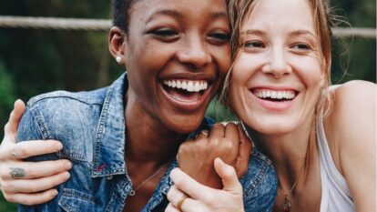 two women laughing and hugging