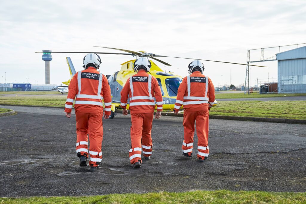 A Pilot, Doctor, and Critical Care Paramedic walking towards one of our helicopters.