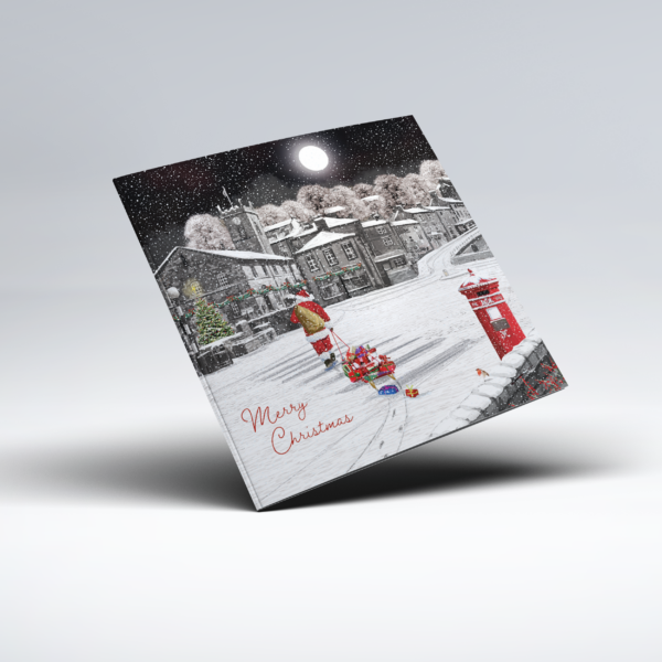Illustrated Christmas card showing Father Christmas pulling a small sleigh piled with colourful wrapped presents through a snow-covered village. A bright full moon shines above stone houses and snowy trees, with a traditional red postbox in the foreground and the words "Merry Christmas" at the lower left.