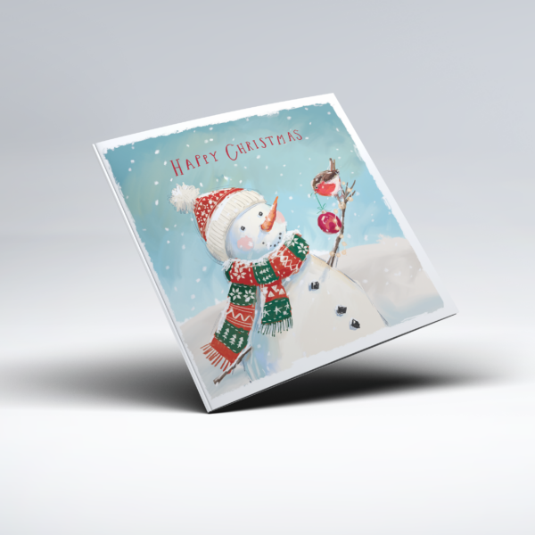 Illustrated Christmas card showing a snowman wearing a red, green and white patterned hat and scarf, with a carrot nose and a robin perched on a twig beside a red bauble. Snow falls against a pale blue background, with the words "Happy Christmas" above.