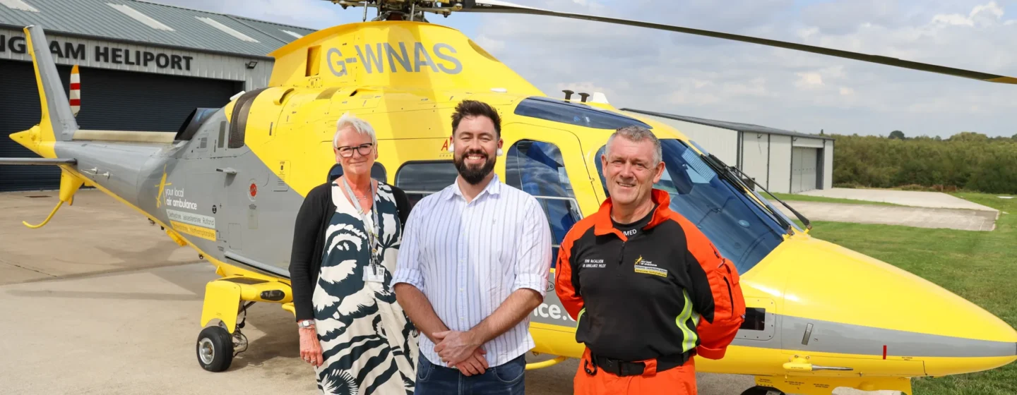 Left to right: CEO Peta Wilkinson, Adam Thompson MP and Pilot John McCallion in front of an air ambulance.