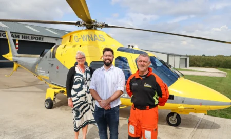 Left to right: CEO Peta Wilkinson, Adam Thompson MP and Pilot John McCallion in front of an air ambulance.