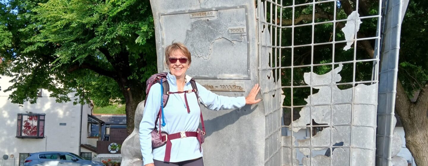 Anne Stephenson, a fundraiser, in front of the starting point monument at Minehead, Somerset.