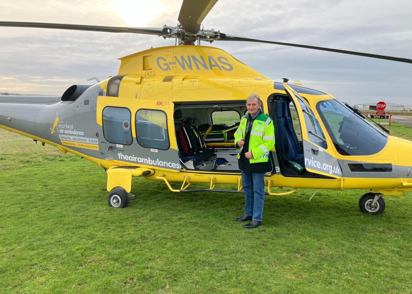 John Murphy on a base visit, standing in front of a helicopter.