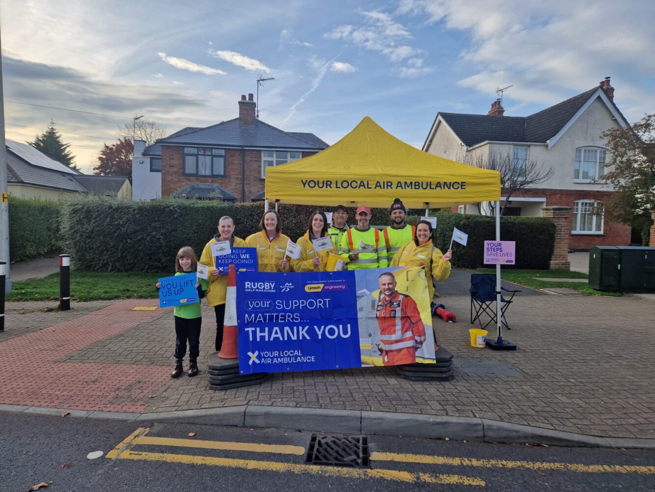 Staff and volunteers at the marathon, with banners and flags.