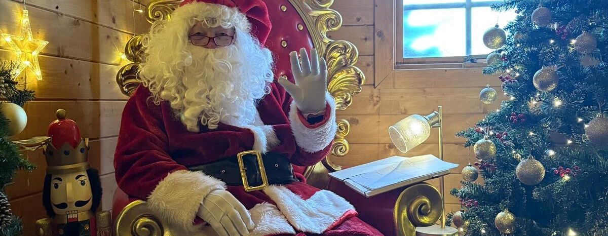 Roger dressed as Santa, sitting in his grotto.