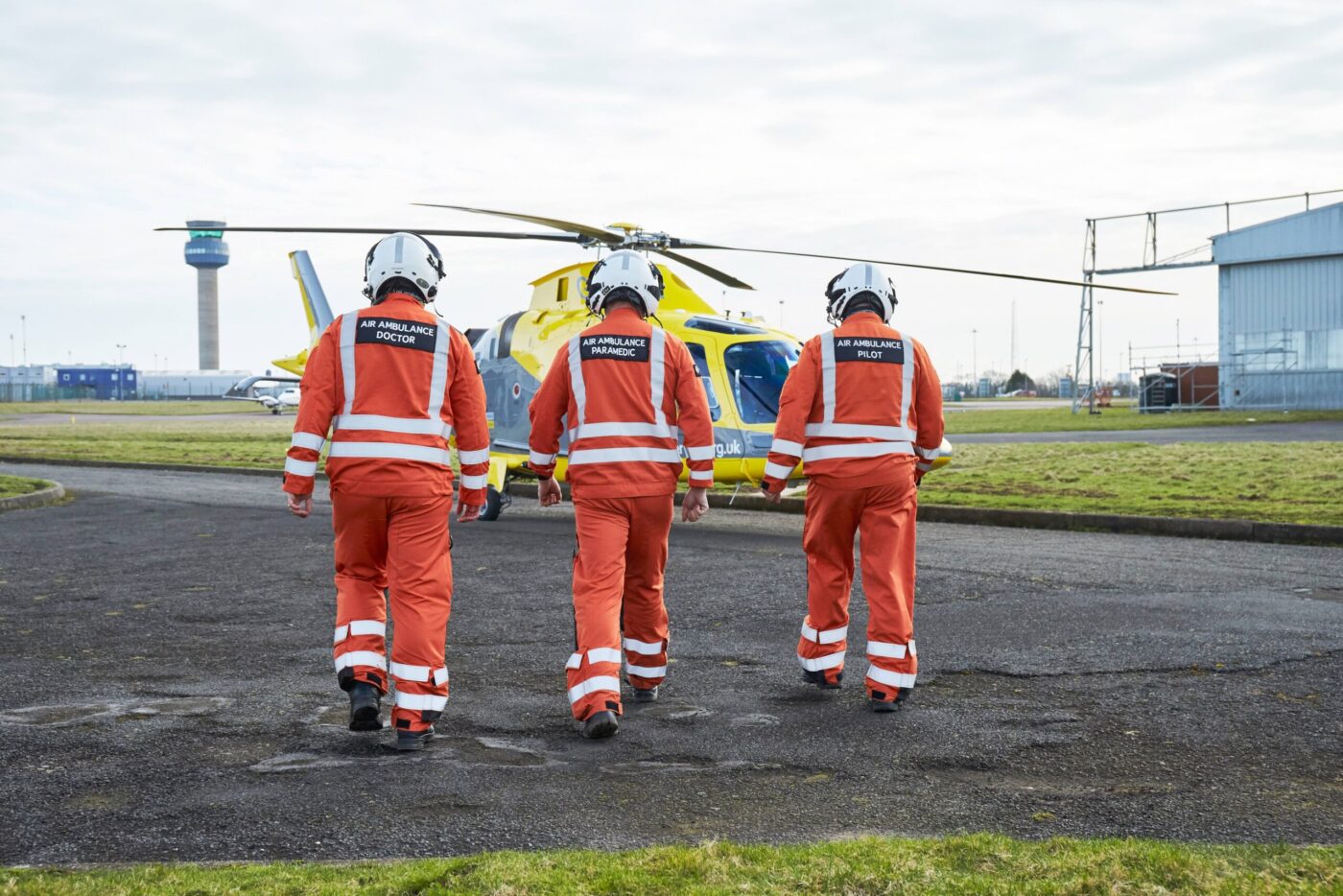 A Pilot, Doctor, and Critical Care Paramedic walking towards one of our helicopters.