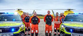 A groupshot of some of our crew with two of our critical care cars and two of our helicopters in the background.