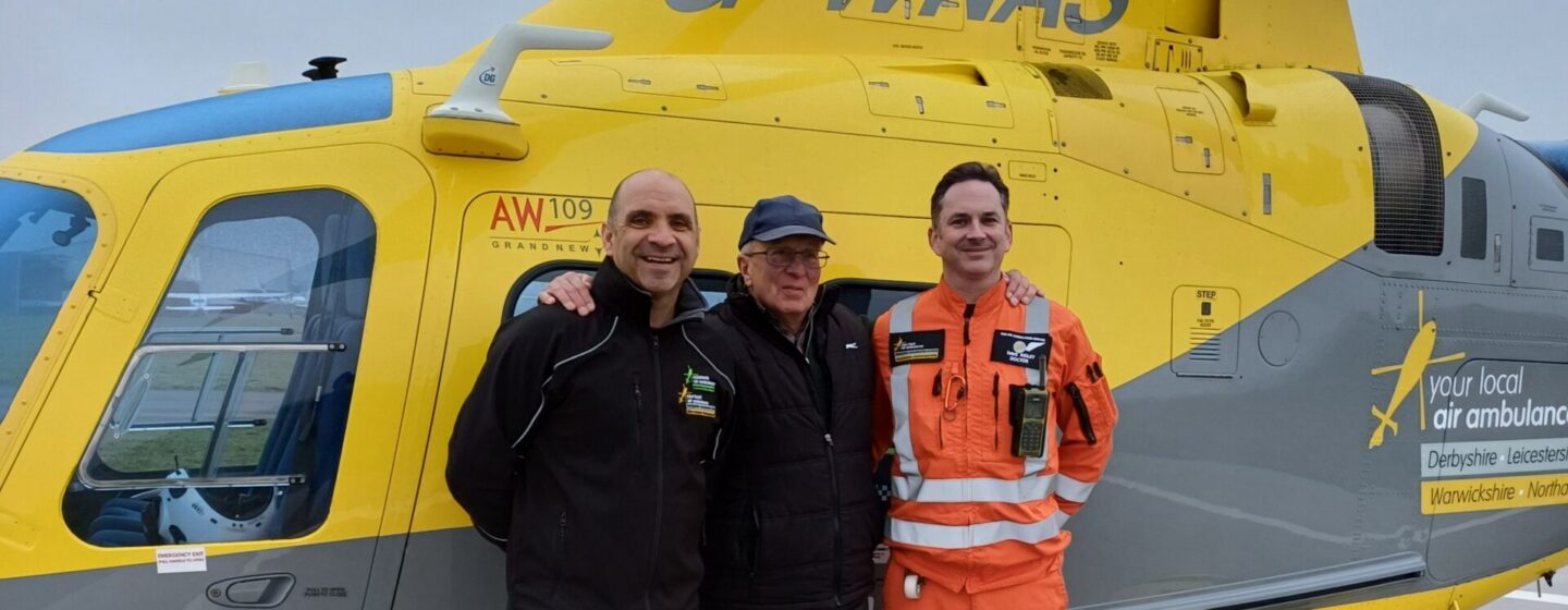 Stephen on a base visit, standing with the crew who saved his life, in front of the helicopter.