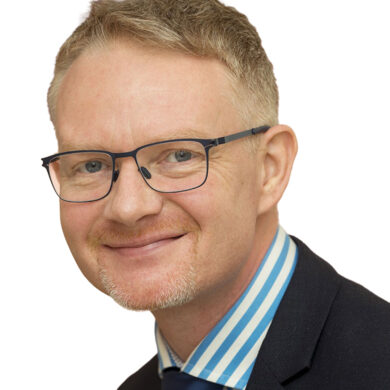 Headshot of Phil White, Non-Executive Director at The Air Ambulance Service. He is smiling to the camera, wearing glasses and a suit.