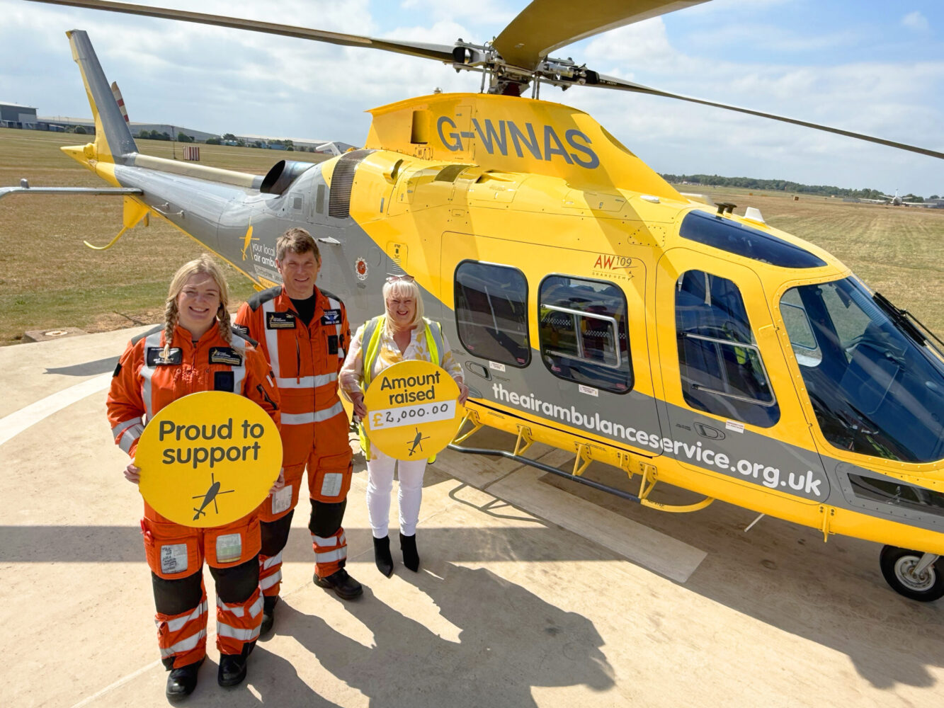 air ambulance staff and corporate supporter from Kite standing outside a helicopter