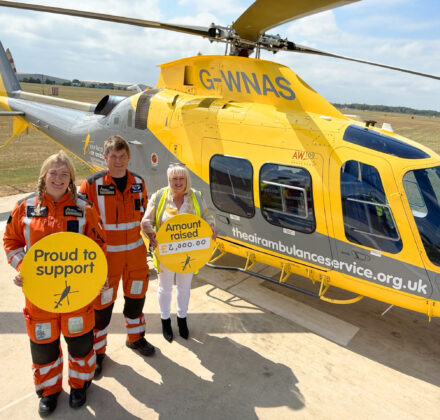 air ambulance staff and corporate supporter from Kite standing outside a helicopter