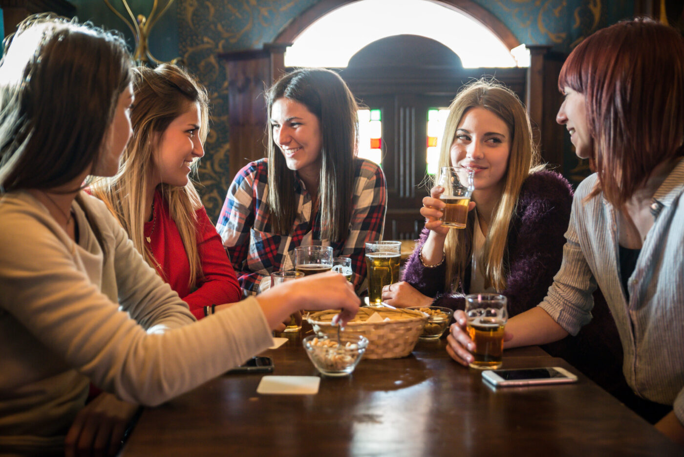 Group of happy friends having party in a bar - Young people drinking beer