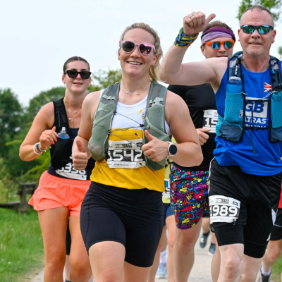 woman running in your local air ambulance vest smiling