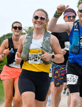 woman running in your local air ambulance vest smiling